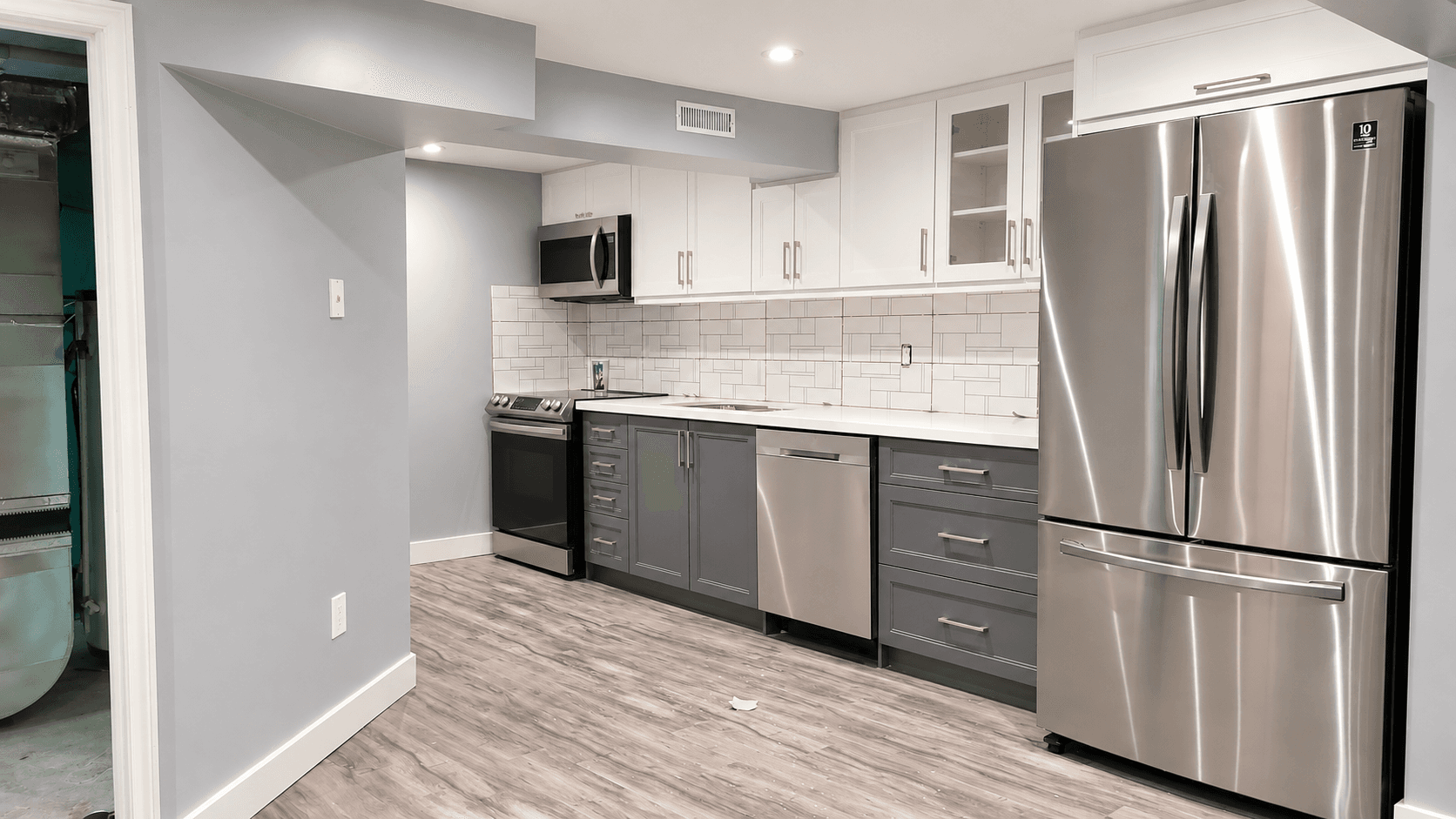 Grey and white basement kitchen with recessed lighting